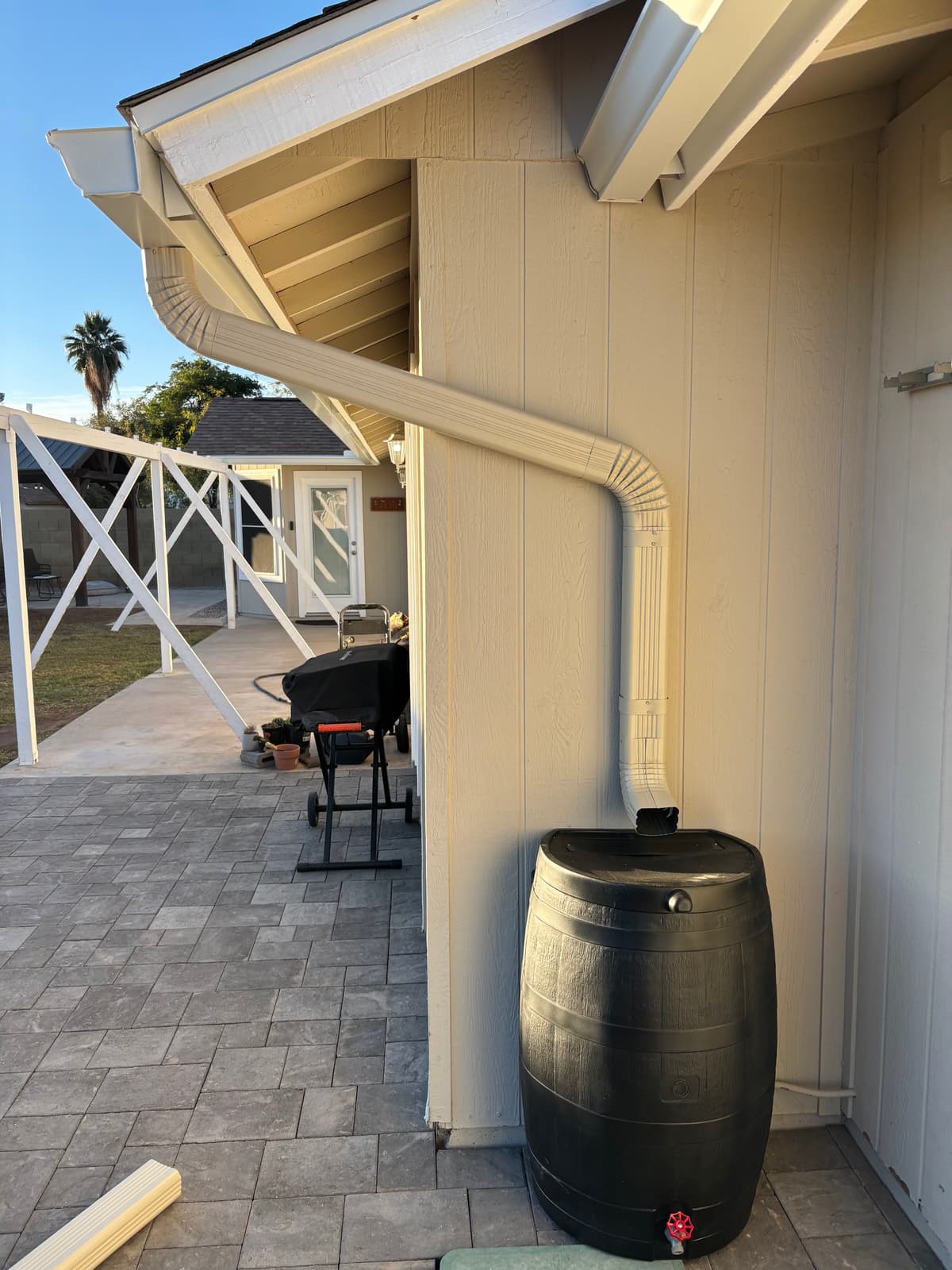 Rain barrel water catchment system connected to downspout on an Arizona home — Grizzly Rain Gutters