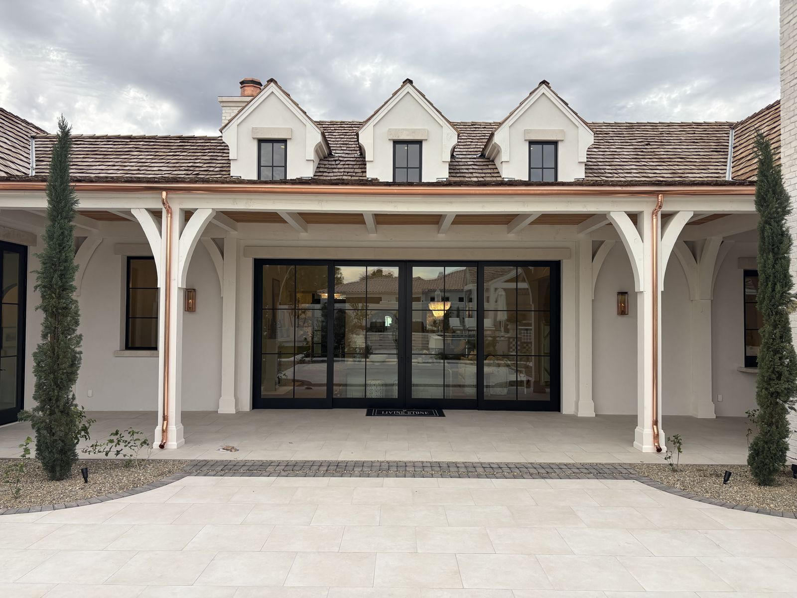 Copper gutters and dual round downspouts on covered porch columns — Grizzly Rain Gutters