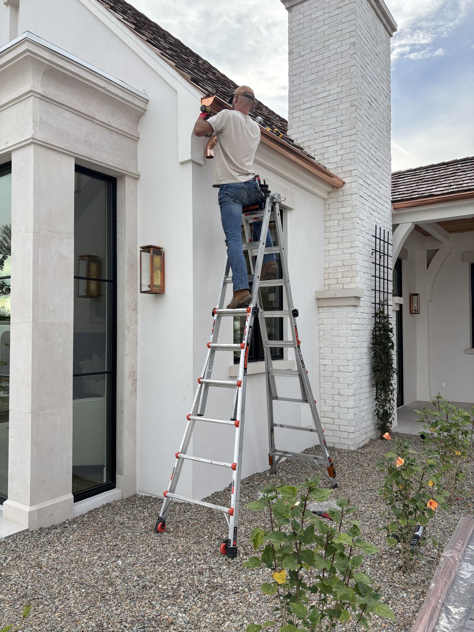 Grizzly Gutters crew installing copper downspout on upscale estate home