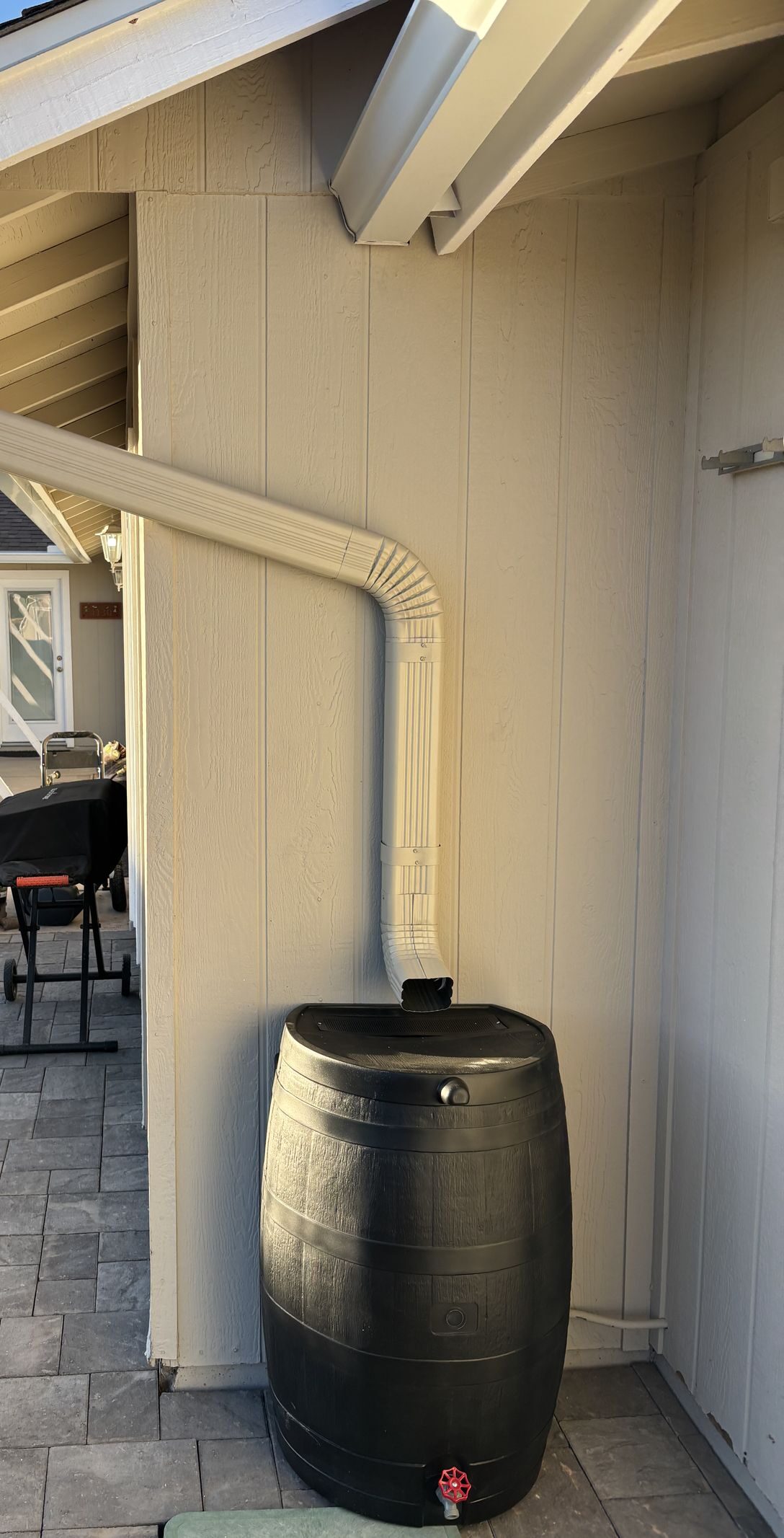 Aluminum downspout routed into rain barrel water collection — Grizzly Rain Gutters